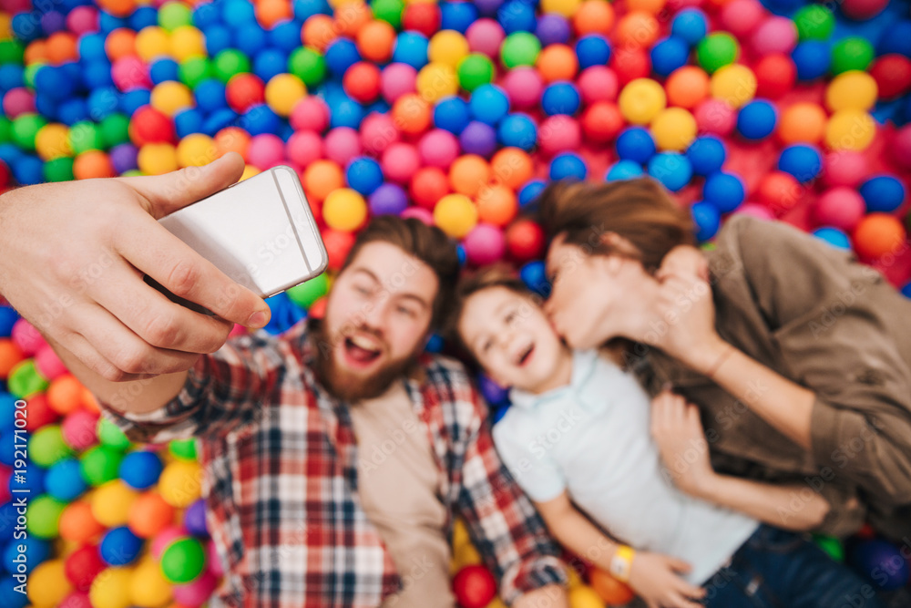 Obraz premium Happy little child have fun with his parents make selfie