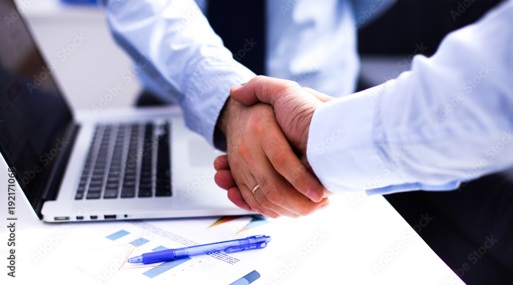 Business people handshake, sitting at the table Business people handshake, sitting at the table