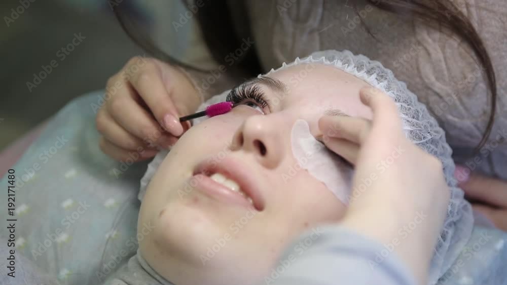 A young girl increases eyelashes in a beauty salon. The process of increasing and volumetric eyelash extensions to a blonde girl. A young girl increases eyelashes in a beauty salon. The process of increasing and volumetric eyelash extensions to a blonde girl.