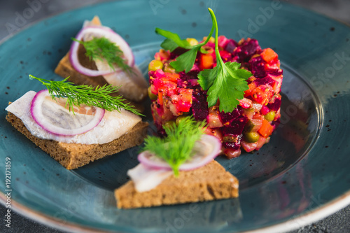 Traditional Russian beetroot salad vinaigrette with sandwich fish on bread