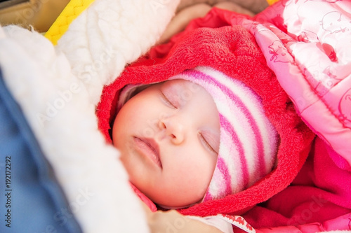 Cute baby sleeping in winter clothes and a warm blanket.