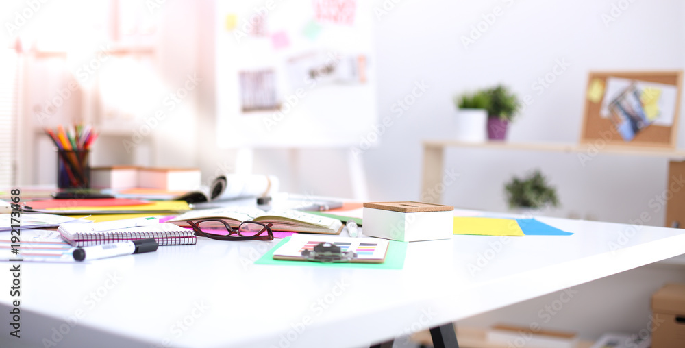 Desk of an artist with lots of stationery objects. Studio shot on wooden background