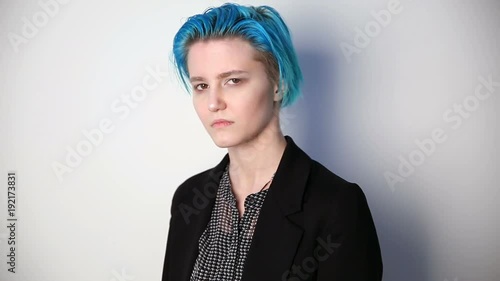 modern youth. calm portrait of a serious girl of unusual appearance with blue hair.