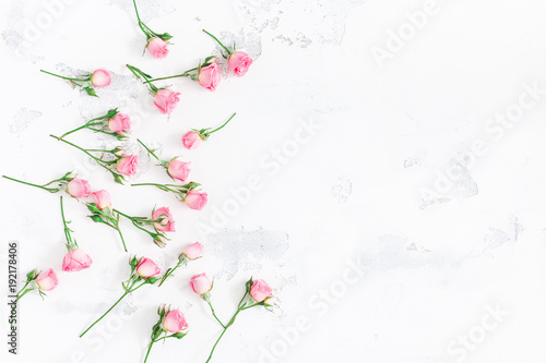 Flowers composition. Frame made of pink rose flowers on white wooden background. Flat lay, top view, copy space
