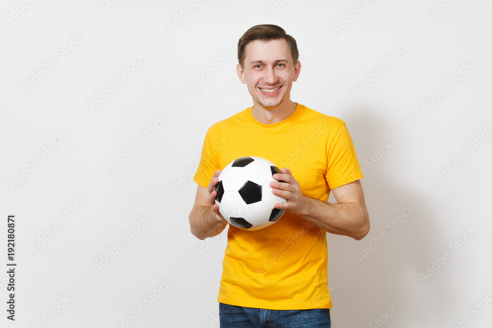 Inspired young cheerful European man, fan or player in yellow uniform hold soccer ball, cheer favorite football team isolated on white background. Sport, play football, healthy lifestyle concept. Inspired young cheerful European man, fan or player in yellow uniform hold soccer ball, cheer favorite football team isolated on white background. Sport, play football, healthy lifestyle concept.