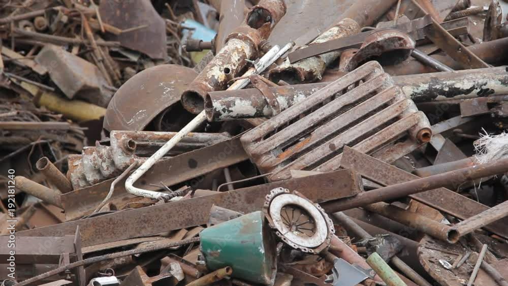 Sorting and loading of scrap metal/Excavator is loading scrap metal junk into a bin at a garbage dump or recycling center. Sorting and loading of scrap metal/Excavator is loading scrap metal junk into a bin at a garbage dump or recycling center.