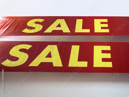 The word sale in English printed big yellow letters on a red background. The concept of seasonal sales