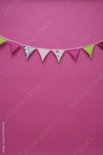 Bunte Girlande vor pinkfarbenem Hintergrund