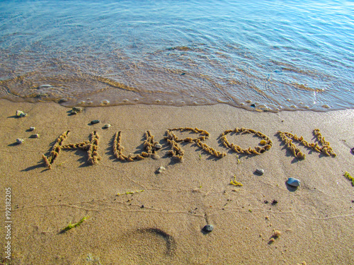 Hand drawn word on sandy beach at Lake Huron.
Close up detailed image of sand, text and lake water.