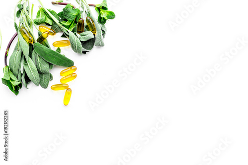 Alternative medicine. Phytotheraphy. Herbs and pills on white background top view copy space photo