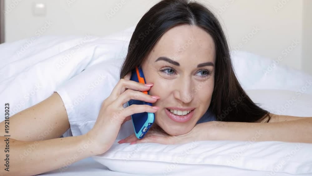 Female with telephone lying down on the bed Female with telephone lying down on the bed
