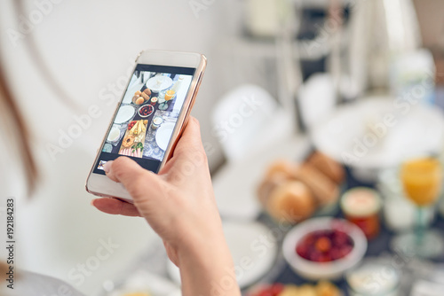 Junge Frau fotografiert den Frühstückstisch photo