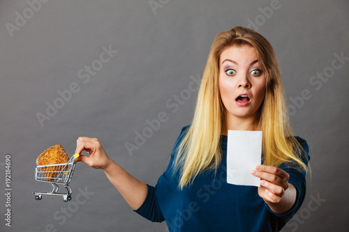 Shocked woman holding shopping basket with bread photo