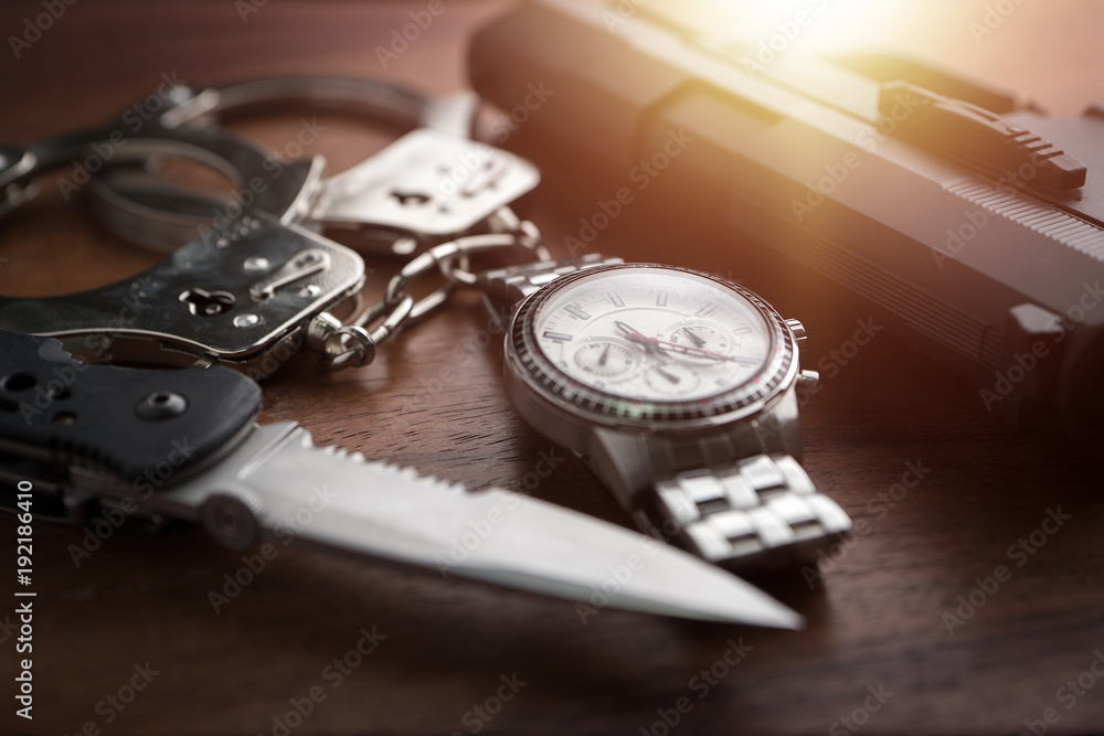 Tactical gear set of Pistol gun knife handcuff and clock on wooden background. Police or military equipment concept. Tactical gear set of Pistol gun knife handcuff and clock on wooden background. Police or military equipment concept.