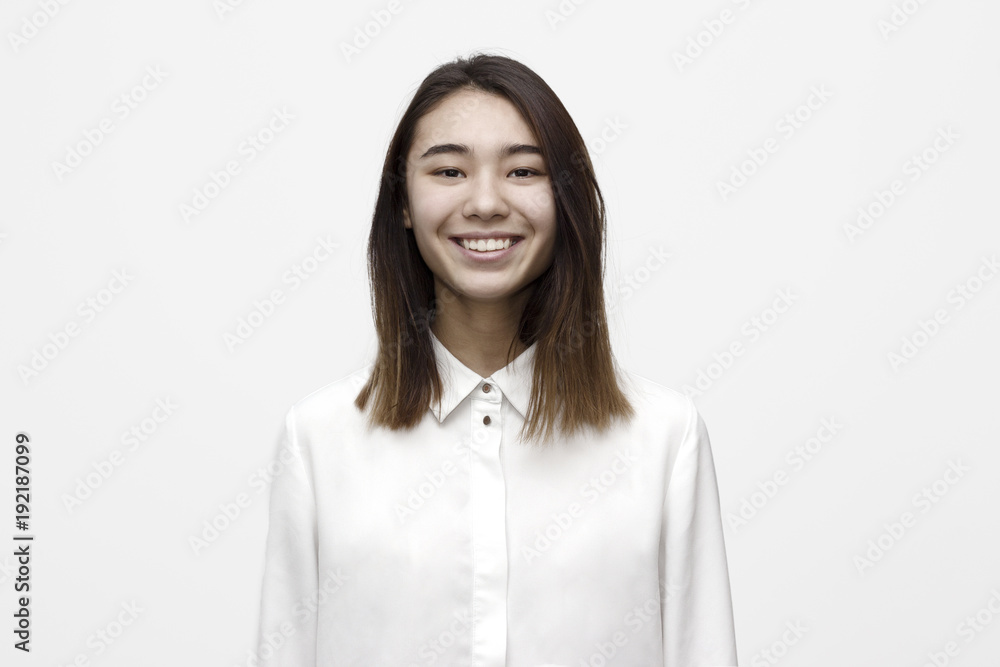 Indoor portrait of young attractive and very happy woman smiling in white formal shirt on the white background. Emotions, feelings, lifestyle concept Indoor portrait of young attractive and very happy woman smiling in white formal shirt on the white background. Emotions, feelings, lifestyle concept