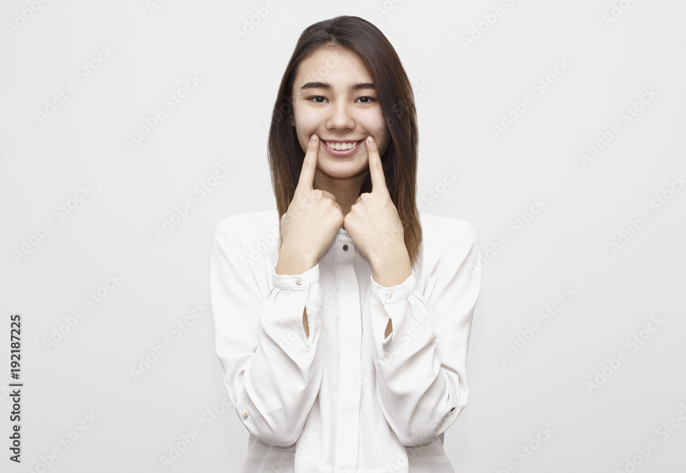 Charming broadly smiling with perfect teeth young woman touching her cheecks, showing smile. Face expressions, feelings, emotions concept Charming broadly smiling with perfect teeth young woman touching her cheecks, showing smile. Face expressions, feelings, emotions concept