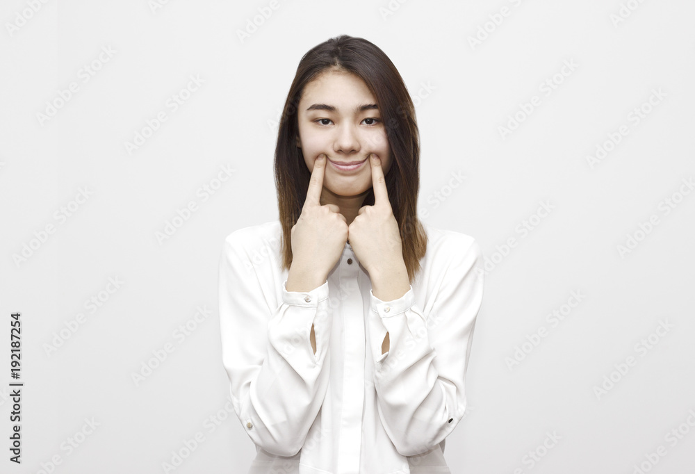 Charming broadly smiling without teeth young woman touching her cheecks, showing smile. Face expressions, feelings, emotions concept Charming broadly smiling without teeth young woman touching her cheecks, showing smile. Face expressions, feelings, emotions concept