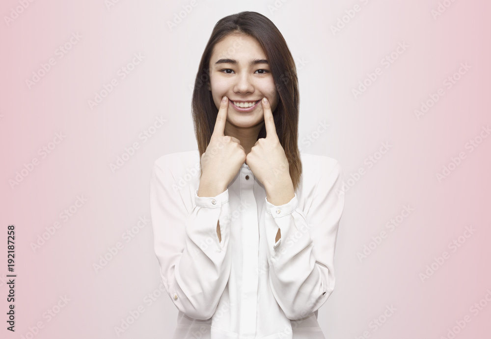 Portrait of young beautiful woman making wide smile with two fingers. Perfect teeth, dental care concept. Emotions, face expressions, lifestyle concept Portrait of young beautiful woman making wide smile with two fingers. Perfect teeth, dental care concept. Emotions, face expressions, lifestyle concept