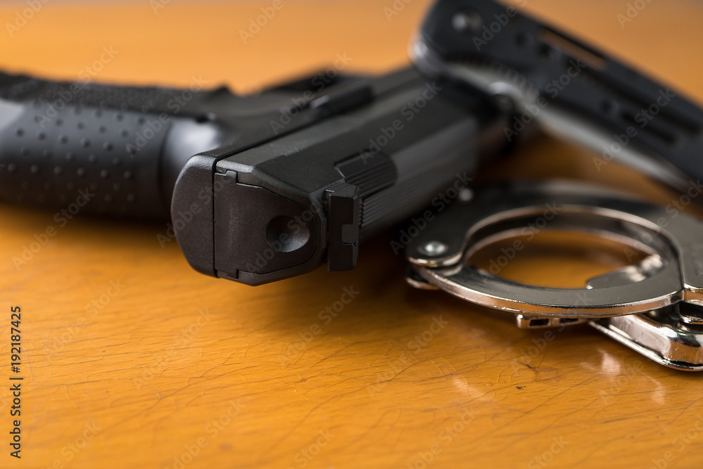 Obraz premium Tactical gear set of Pistol gun knift handcuff and clock on wooden background. Police or military equipment concept.