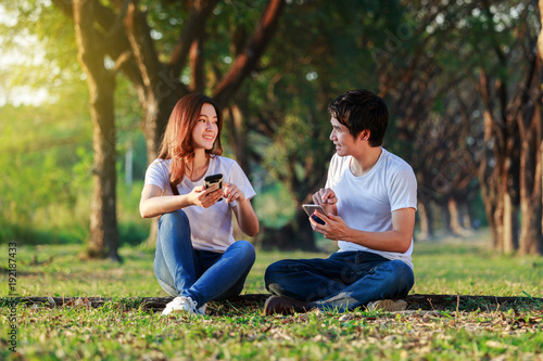 couple using mobile phone and talking in park © geargodz