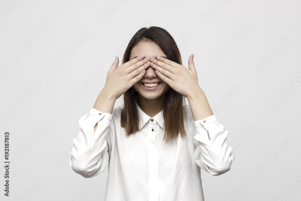 Closeup portrait young, coy woman closing eyes with hands can't see and hiding mouth wide open, isolated white background. See no evil concept. Negative emotion facial expression feelings Closeup portrait young, coy woman closing eyes with hands can't see and hiding mouth wide open, isolated white background. See no evil concept. Negative emotion facial expression feelings