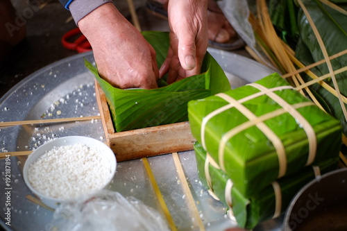 Packing Banh Chung (sticky rice cake), this is a traditional Vietnamese rice cake which is made from glutinous rice, mung beans, pork and other ingredients. photo