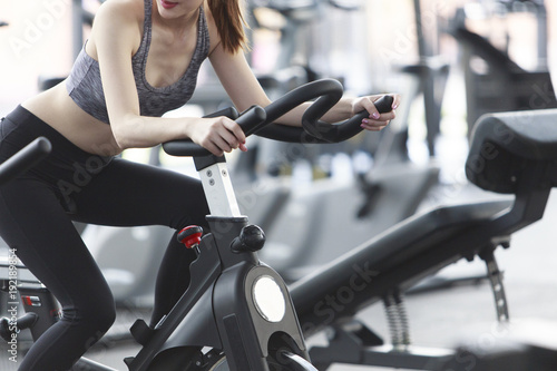 Close-up footage of a women working out in gym on the exercise bike, young woman cycling in the gym. female exercising in fitness gym for good health.