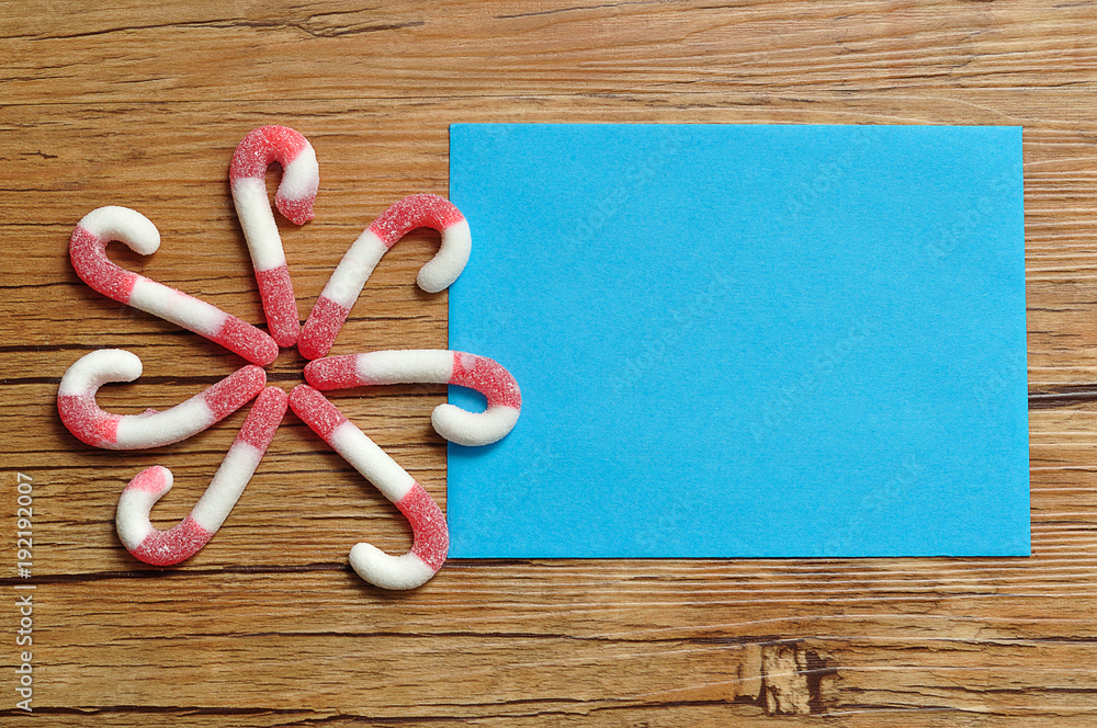 A flower pattern made out of candy canes with an empty blue note pad