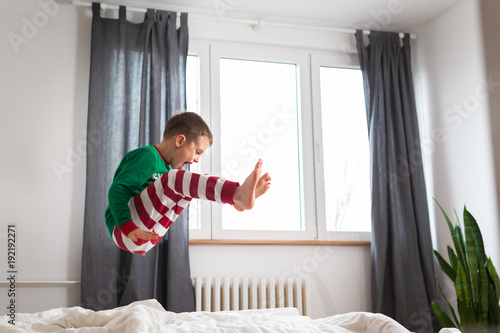 little boy jumping on bed in bedroom