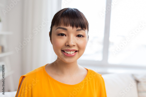 portrait of smiling young asian woman at home
