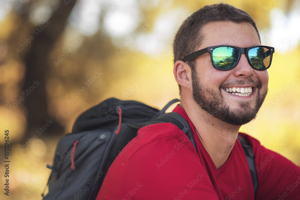 Happy young man with backpack hiking in the woods Happy young man with backpack hiking in the woods