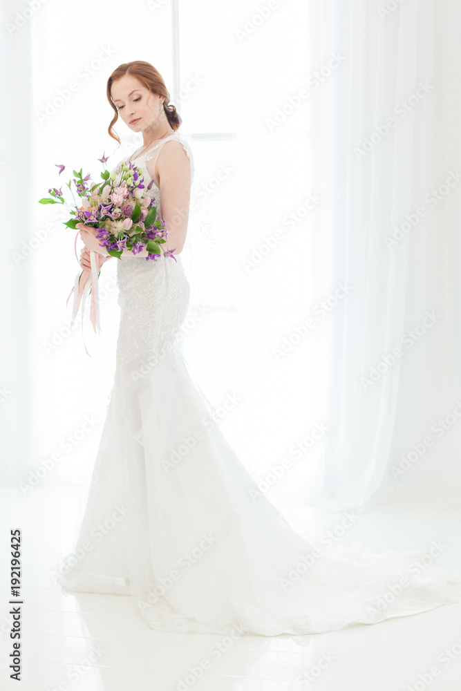 Bride in a wedding dress against a light window. Bride in a wedding dress against a light window.