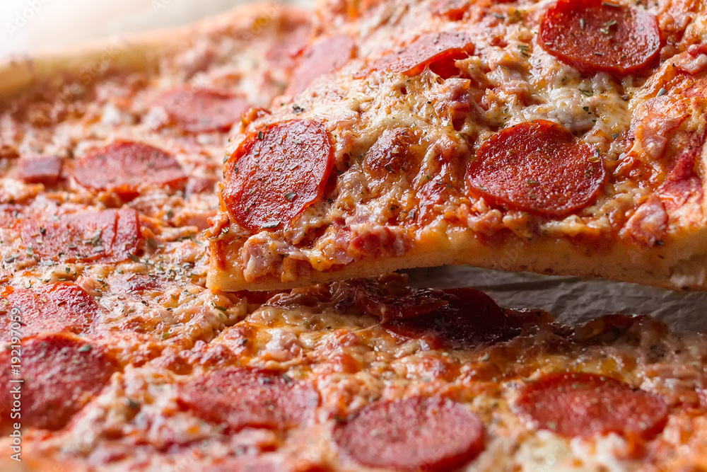 Pepperoni pizza with one slice cut off Pepperoni pizza with one slice cut off