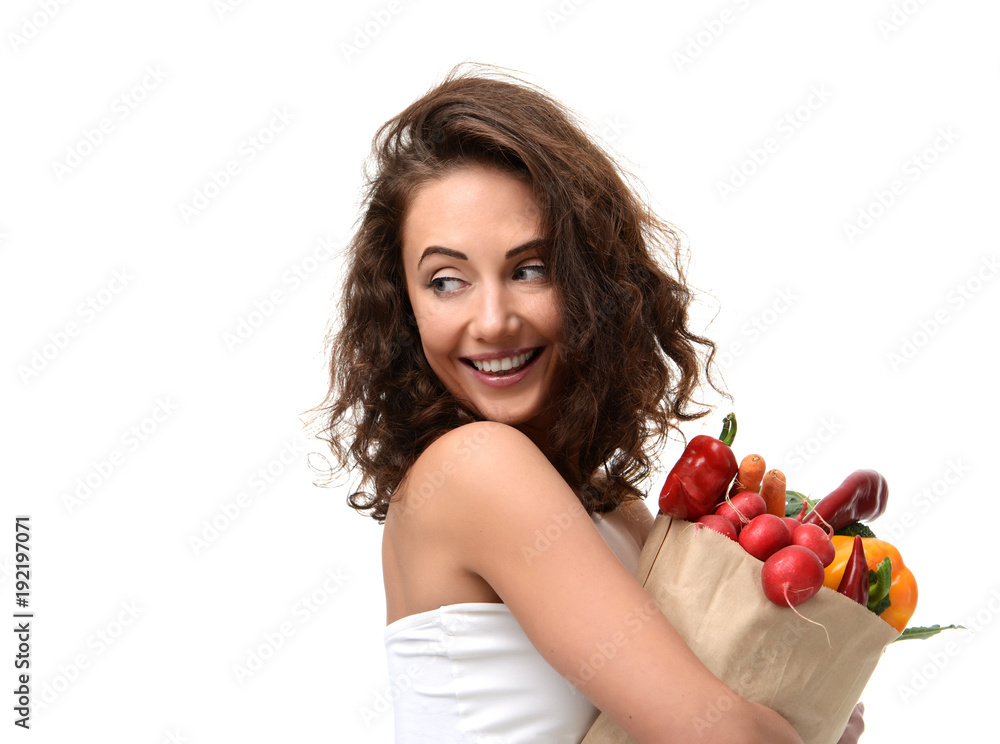 Young woman holding grocery paper shopping bag full of fresh vegetables. Diet healthy eating concept Young woman holding grocery paper shopping bag full of fresh vegetables. Diet healthy eating concept