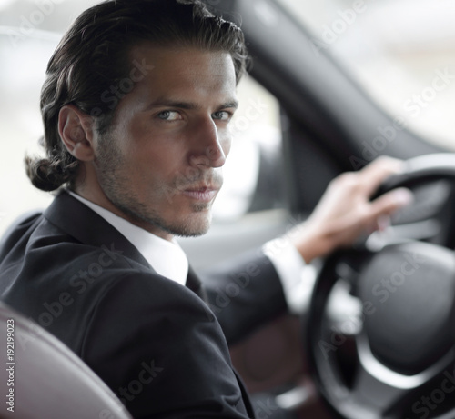 man sitting behind the wheel of a car