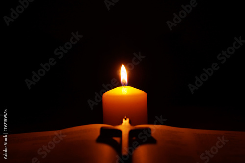 Obraz na płótnie Burning candle, open Bible and crucifix in the dark. w salonie