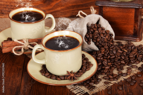 a linen bag full of coffee beans with a cup of freshly brewed black coffee