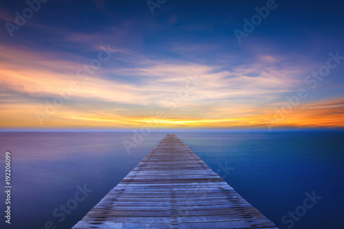 Fototapeta Naklejka Na Ścianę i Meble -  Wooden bridge on sea at sunset