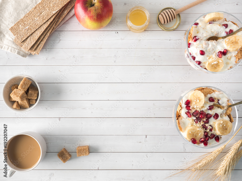 Glass bowl with muesli and yogurt with banana, pomegranate seeds Copy space Glass bowl with muesli and yogurt with banana, pomegranate seeds Copy space