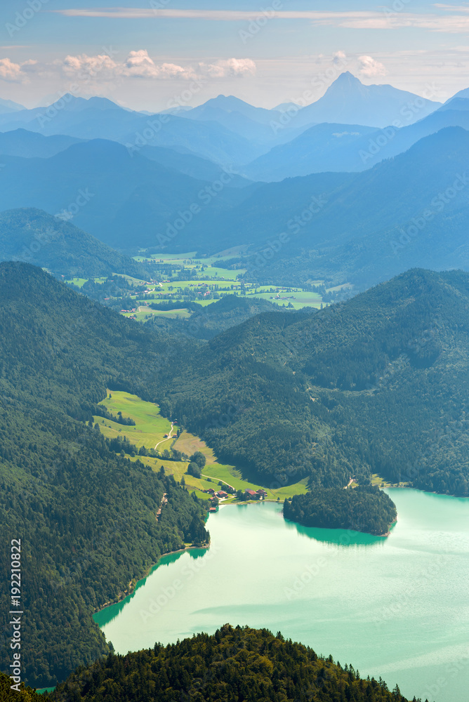 Walchensee lake and green valley against distant mountains