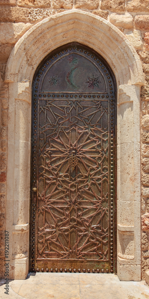 Old metal door with oriental geometric ornament.