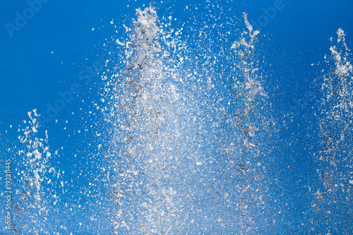 Splashing water from a fountain against the blue sky