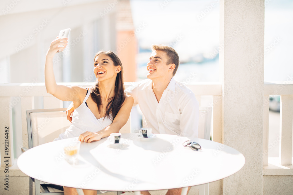 Attractive couple having first date.Coffee with a friend.Smiling happy people making a selfie with a smartphone.Sharing on social media.Technology and relationships concept.Making memories Attractive couple having first date.Coffee with a friend.Smiling happy people making a selfie with a smartphone.Sharing on social media.Technology and relationships concept.Making memories