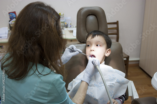 Dentist is treating a boy's teeth