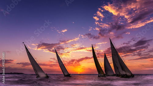 des voiliers naviguent au soleil couchant