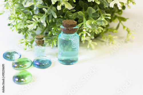 Lime oil skin and hair care home spa. Bottles with blue oil  green leaves. White board background