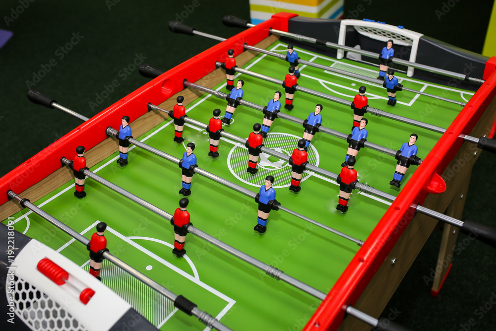 Green wooden table football in the children room. Foosball in children centre with colorful walls on background. Play entertainment centre. Green wooden table football in the children room. Foosball in children centre with colorful walls on background. Play entertainment centre.