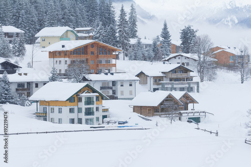 snowing in snow covered winter village © santiago silver