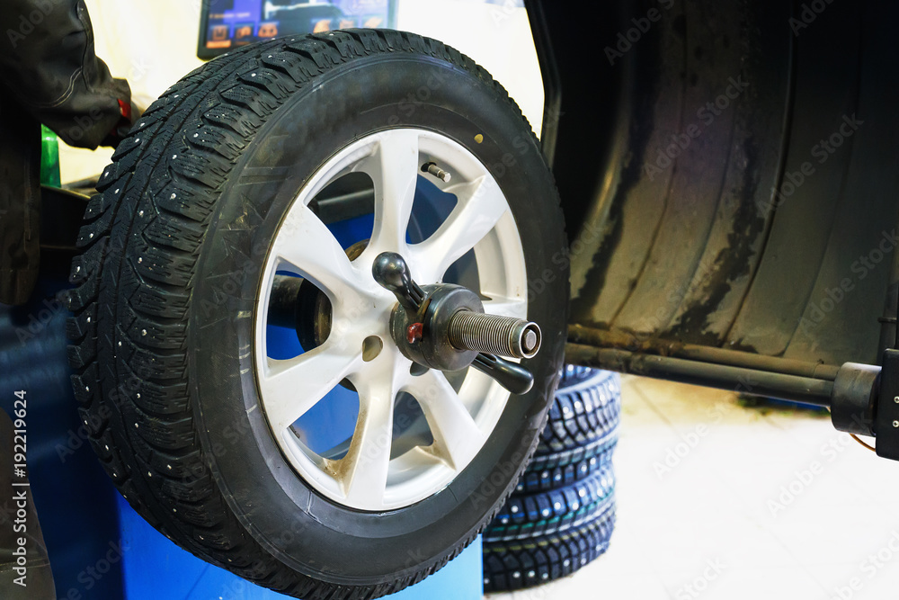 Wheel balancing or repair and change car tire at auto service garage or workshop by mechanic