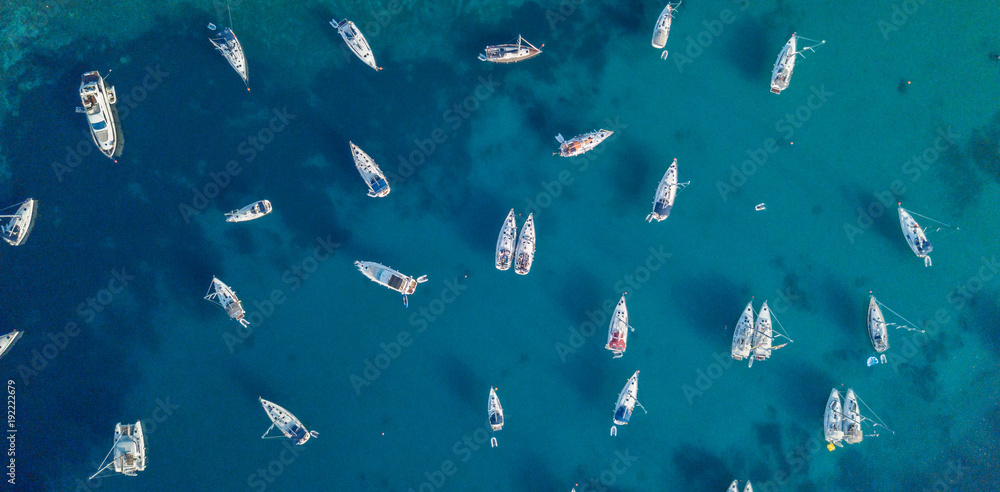 Fototapeta premium Aerial view of many anchoring yacht in open water.